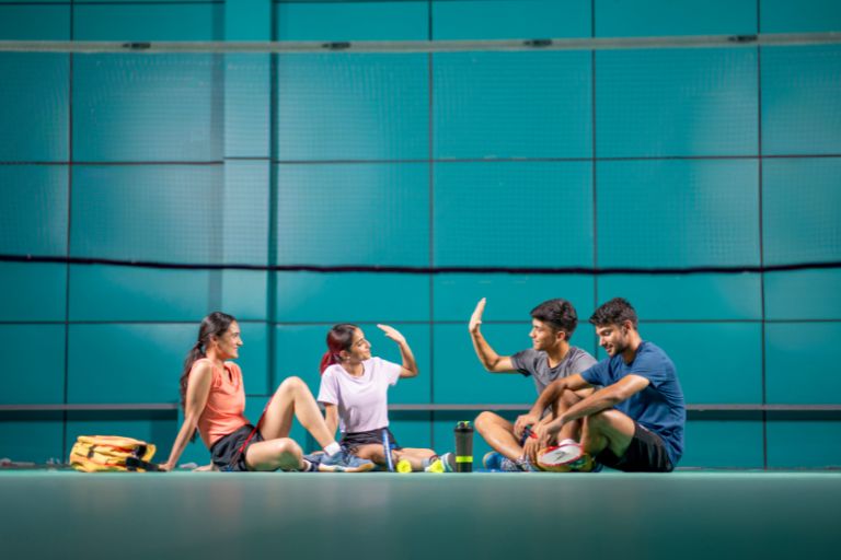 Happy badminton players resting, representing leisure centre software as an all-in-one facility solution