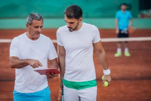 Tennis coach training athlete one on one, showing software for sports coaches focused on growth